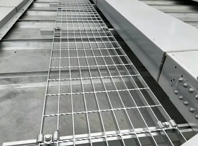Installed bar grating panels on an industrial access structure.